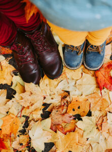 Two pairs of shoes standing in some autumnal leaves