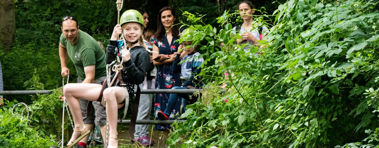 A child smiling while going down a zip wire