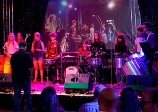 Students performing in a band on stage