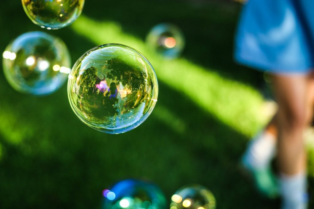 Soap bubbles floating above grass