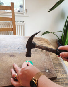 Make holes in the milk bottle lid using a hammer and nail on a wooden board to protect your surfaces