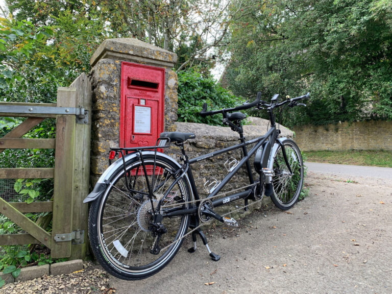 tandem bike leaning against postbox