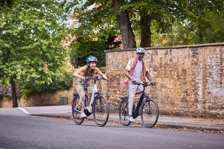 Couple riding ebikes in a town