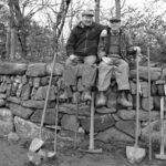 Photo of men sitting on a wall by