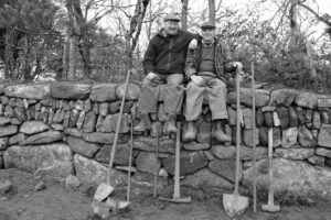 Photo of men sitting on a wall by